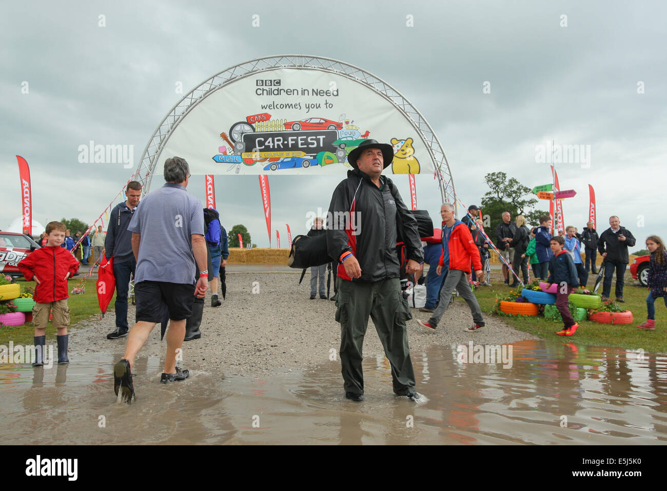 Cheshire, UK. 1. August 2014. Festivalbesucher bekämpfen die Überschwemmungen im Carfest North, die BBC Kinder brauchen Musik und Motoren Festival am Oulton Park in Cheshire.  BBC Kinder brauchen Carfest, organisiert von Promi DJ Chris Evans, war gestern als Freak Sommer unter Wasser untergetaucht Regen die Cheshire Rennstrecke am Eröffnungstag des Festivals getroffen. Bis zu 20.000 Besucher an der Abendkasse am Freitag erwartet wurden aber viele sind vermutlich wegen des schlechten Wetters entfernt gewohnt haben. Bildnachweis: Mark Lees/Alamy Live-Nachrichten Stockfoto