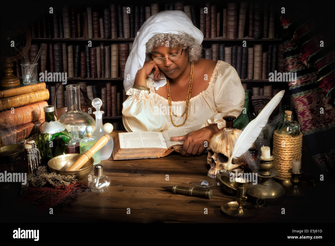 Weibliche Alchemist studieren in ihren Büchern in der Nacht Stockfoto