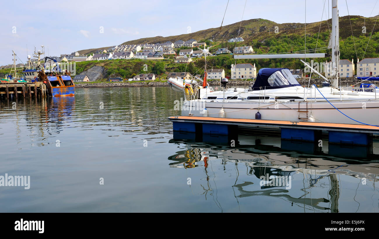 Eine Yacht spiegelt sich in dem ruhigen Wasser von Mallaig Yachthafen, Mallaig, Scotland, UK Stockfoto