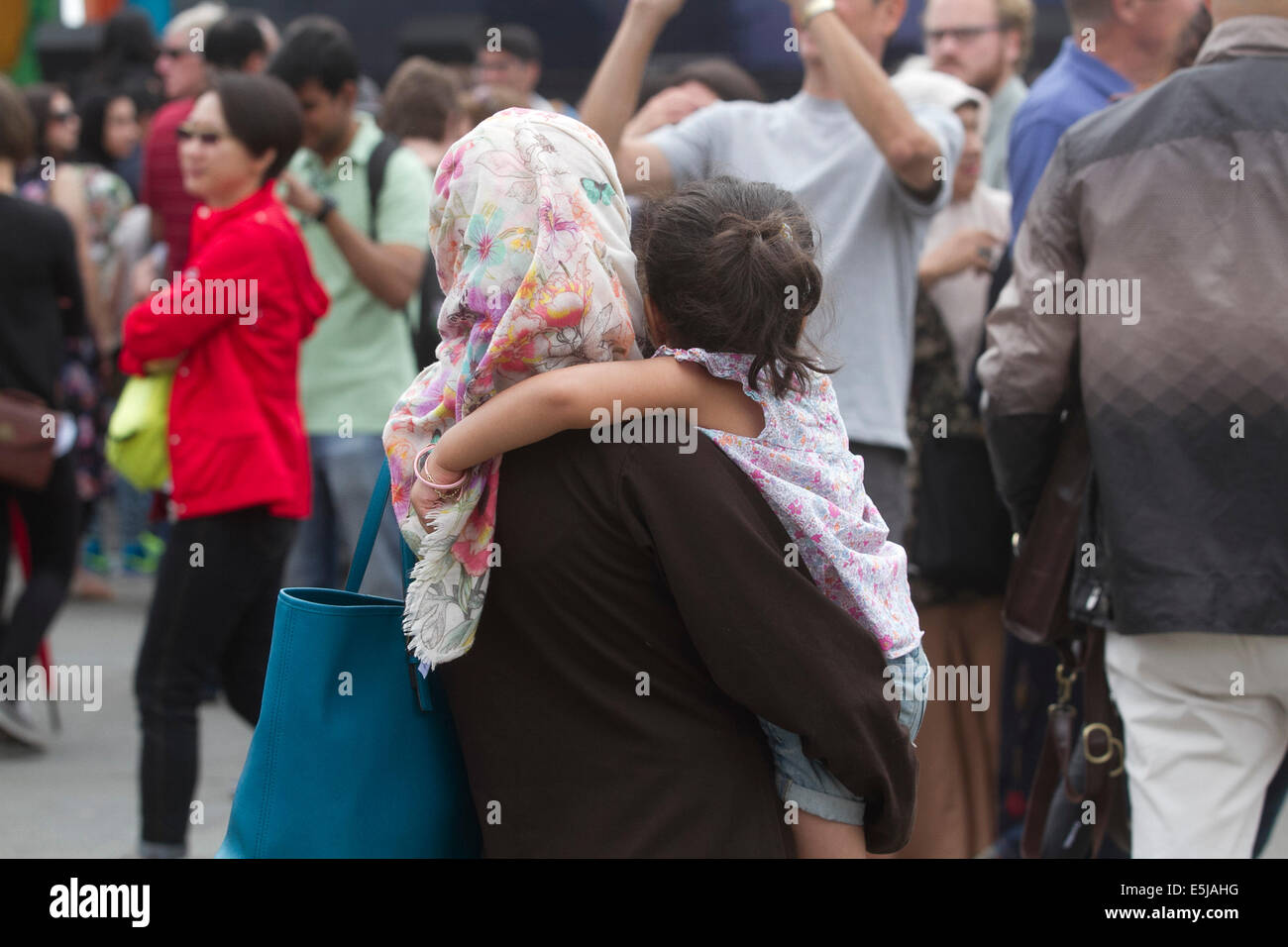 London, UK. 2. August 2014. Eine Mutter trägt ein Kind während der Eid Festival in Trafalgar Square in London, das Ende des Ramadan Credit: Amer Ghazzal/Alamy Live-Nachrichten Stockfoto
