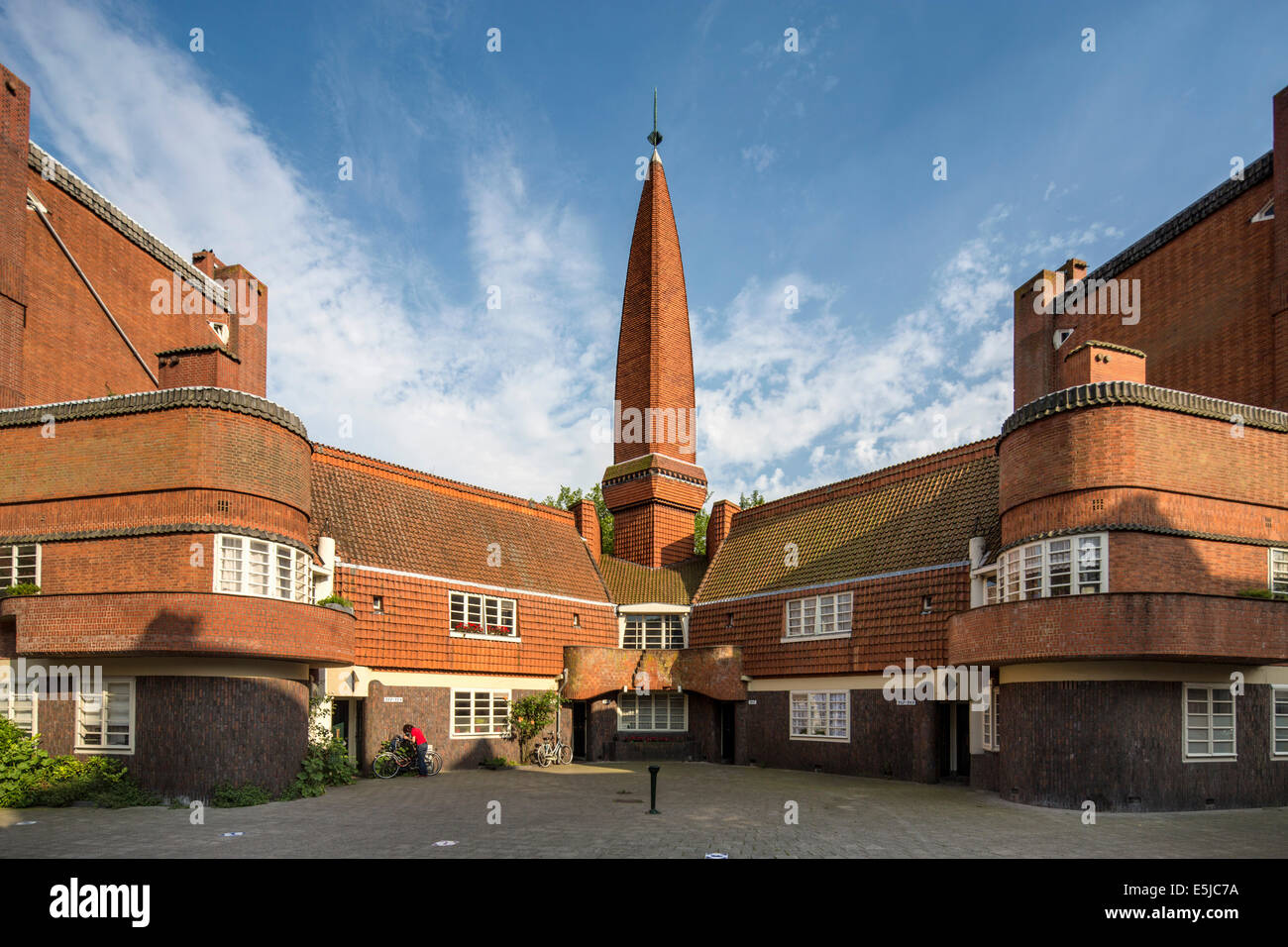 Niederlande, Amsterdam, Stil der Architektur bezeichnet der Amsterdamer Schule, Niederländisch: Amsterdamse School. Frau, Radfahren Stockfoto