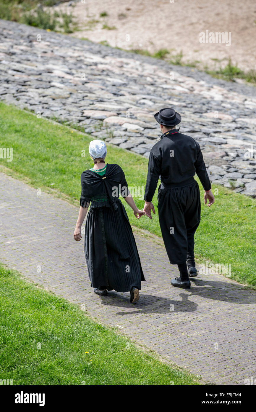 Niederlande, Urk, Mann und Frau im traditionellen Sonntag Kleid am Deich Stockfoto