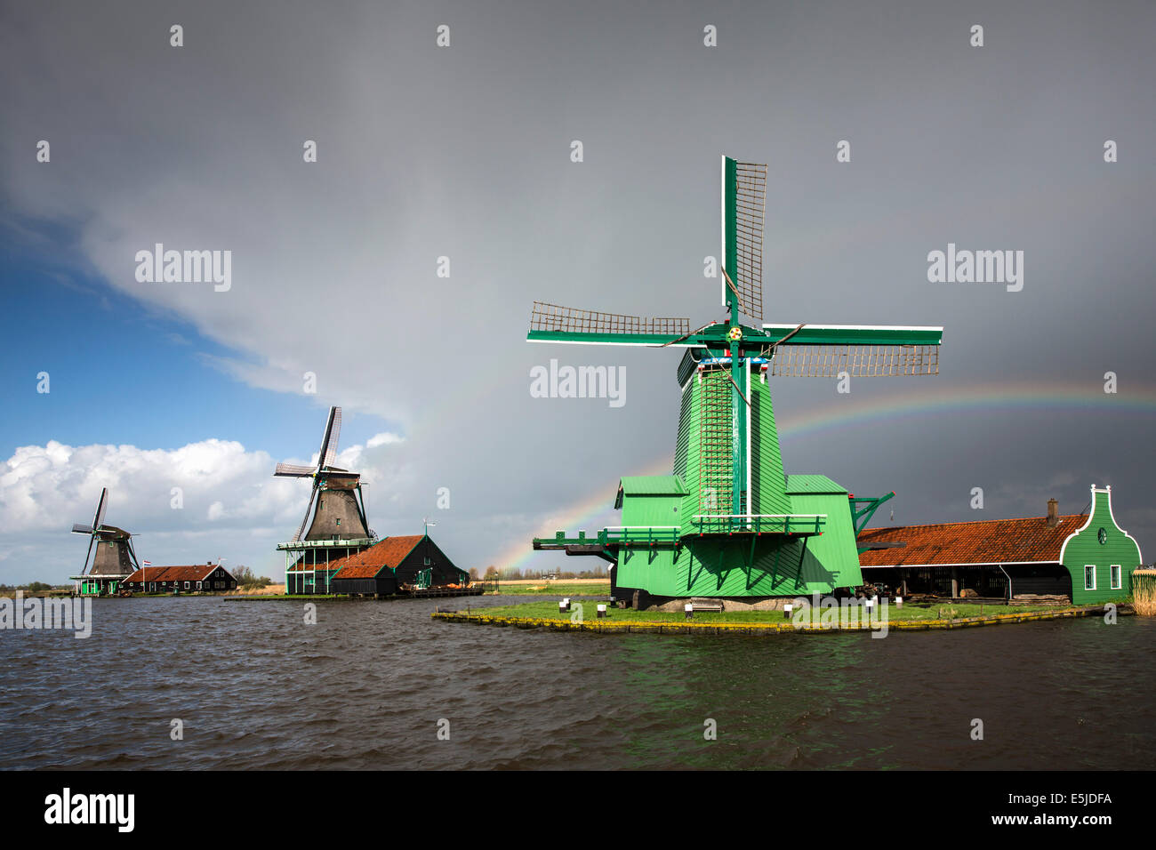 Niederlande, Zaanse Schans in der Nähe von Zaandam, touristische Attraktion mit Windmühlen und Häuser aus dem 17. und 18. Jahrhundert. Regenbogen Stockfoto