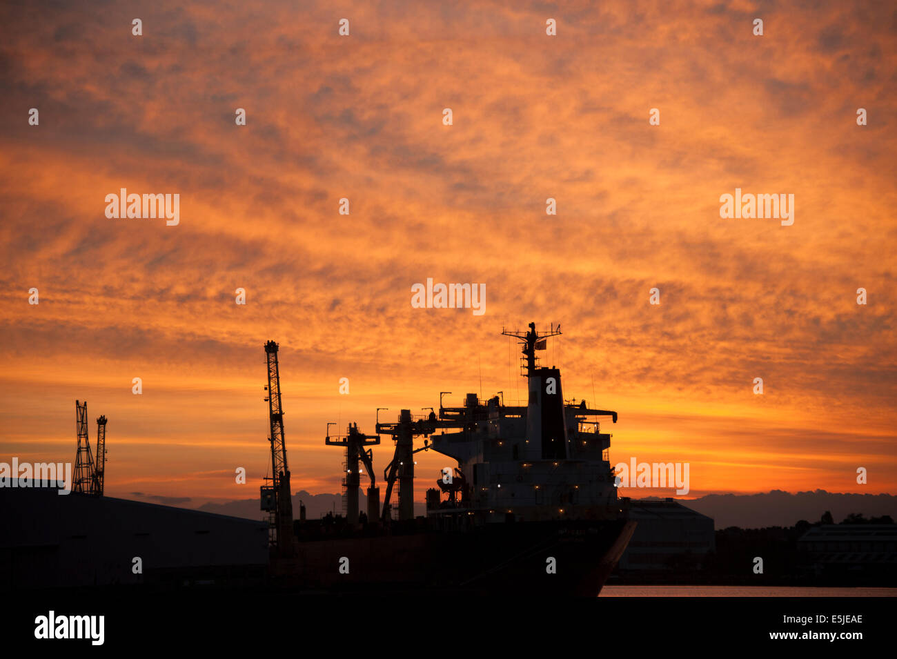 Das Schiff im Dock bei Sonnenuntergang Silhouette rot orange sky Stockfoto