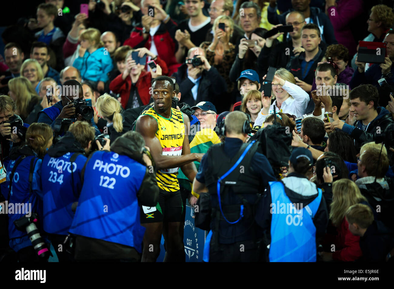 Hampden Park, Glasgow 2. August 2014. Commonwealth Games Männer 4 x 100 endgültig.  Usain Bolt bringt nach Hause den Staffelstab für Jamaika in neuer Rekordzeit Spiele von 37.58.  England wurde Zweiter in 38.02. Jamaikanische Team - Jason Livermore; Kemar Bailey-Cole; Nickel Ashmeade und Usain Bolt. Usain verpflichtet die enthusiastischen Fans mit Selfies und Autogramme Stockfoto