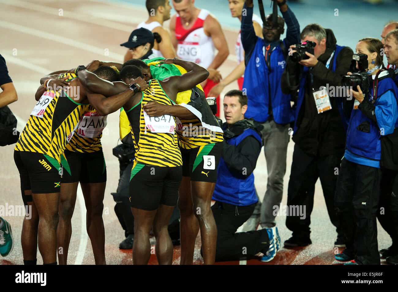 Hampden Park, Glasgow 2. August 2014. Commonwealth Games Männer 4 x 100 endgültig.  Usain Bolt bringt nach Hause den Staffelstab für Jamaika in neuer Rekordzeit Spiele von 37.58.  England wurde Zweiter in 38.02. Jamaikanische Team - Jason Livermore; Kemar Bailey-Cole; Nickel Ashmeade und Usain Bolt. Ein Team huddle für die Kameras. Stockfoto