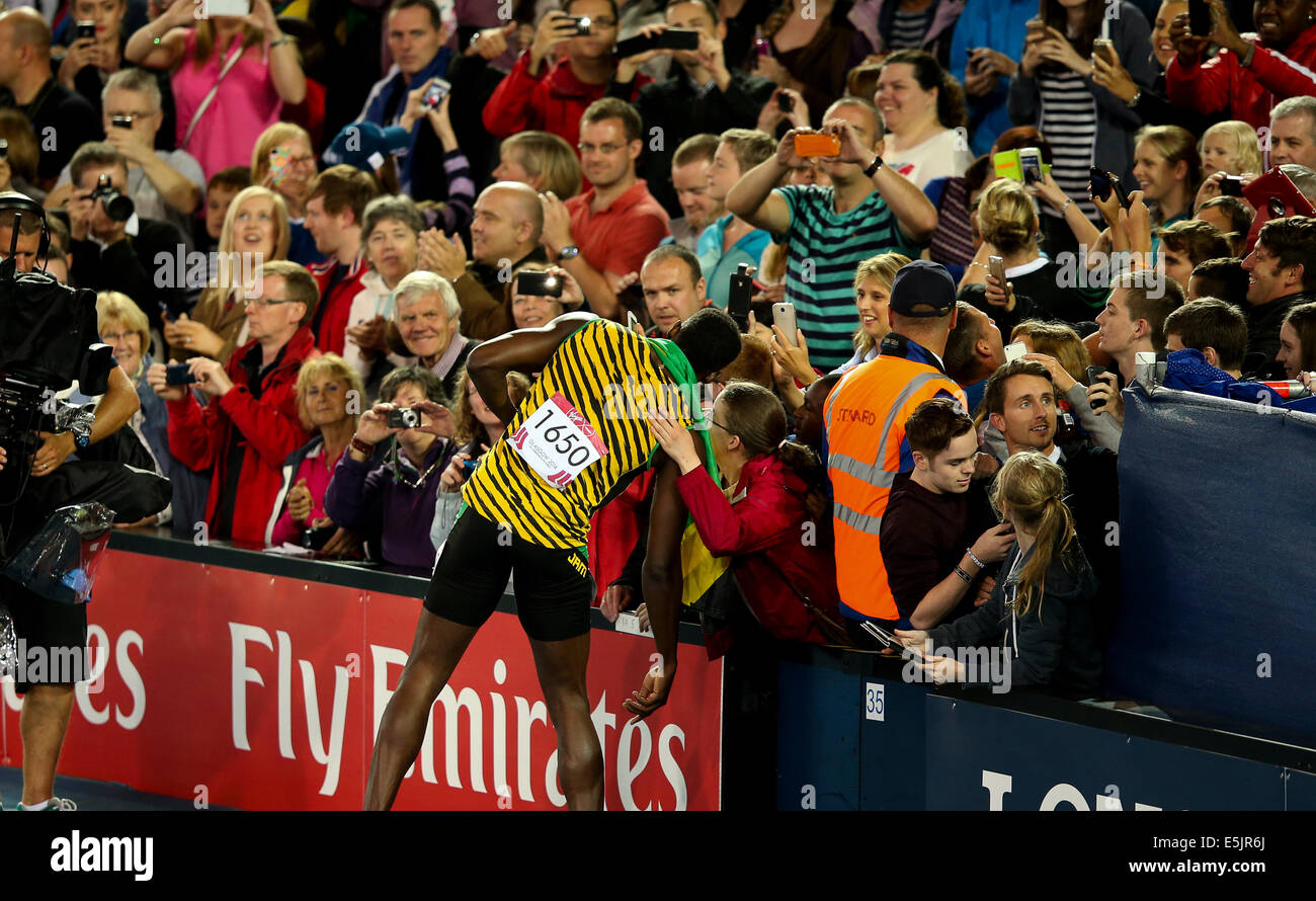 Hampden Park, Glasgow 2. August 2014. Commonwealth Games Männer 4 x 100 endgültig.  Usain Bolt bringt nach Hause den Staffelstab für Jamaika in neuer Rekordzeit Spiele von 37.58.  England wurde Zweiter in 38.02. Jamaikanische Team - Jason Livermore; Kemar Bailey-Cole; Nickel Ashmeade und Usain Bolt. Usain verpflichtet die enthusiastischen Fans mit Selfies und Autogramme Stockfoto