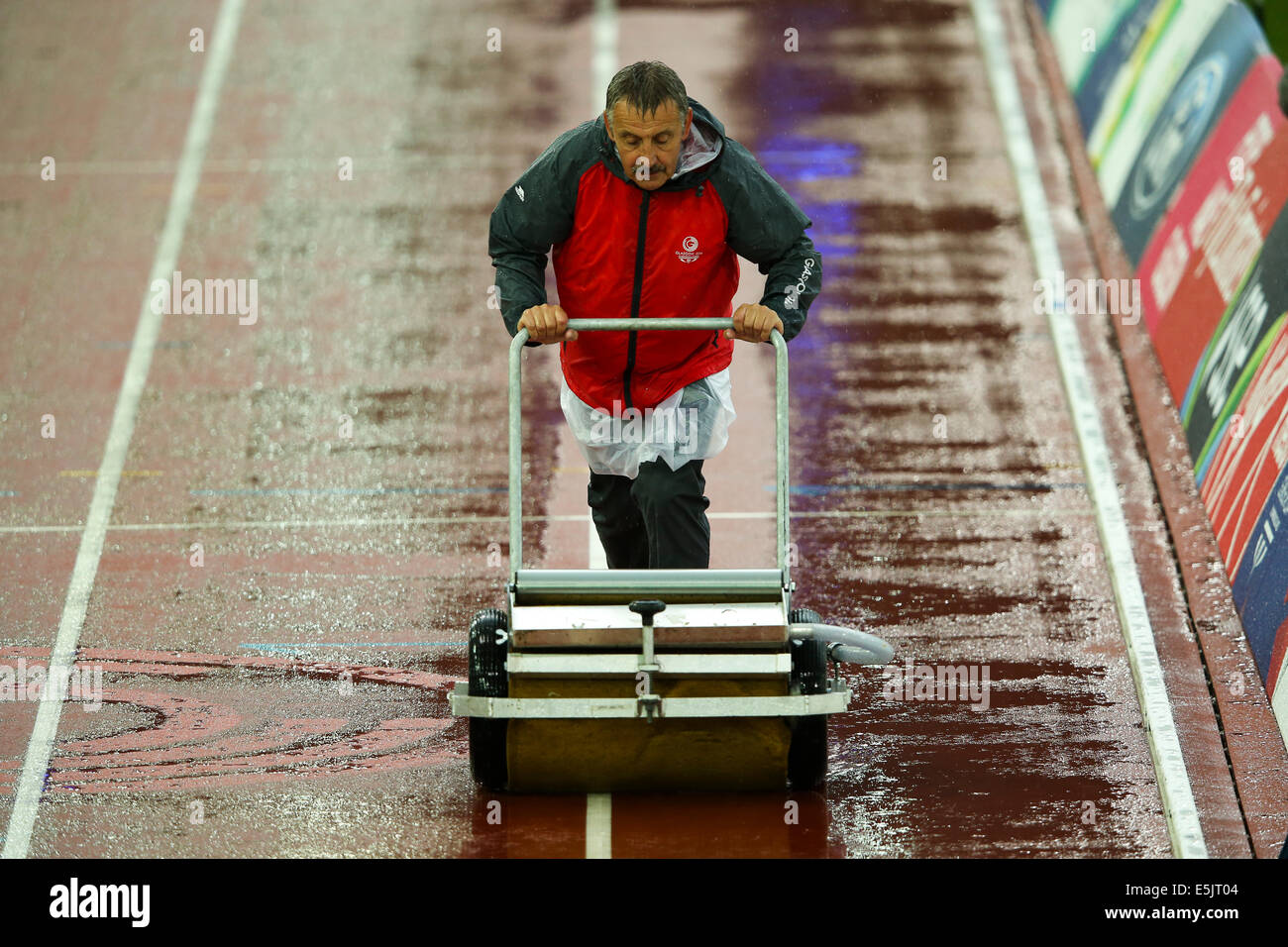 Hampden Park, Glasgow 2. August 2014. Commonwealth Games-Tag 10.   Intermittierende kräftige Schauer behindern die endgültige Leichtathletik-Sitzung im Hampden Park. Kontinuierliche Clearing von stehendem Wasser war nötig, um Wettbewerb zu ermöglichen. Bildnachweis: ALAN OLIVER/Alamy Live-Nachrichten Stockfoto