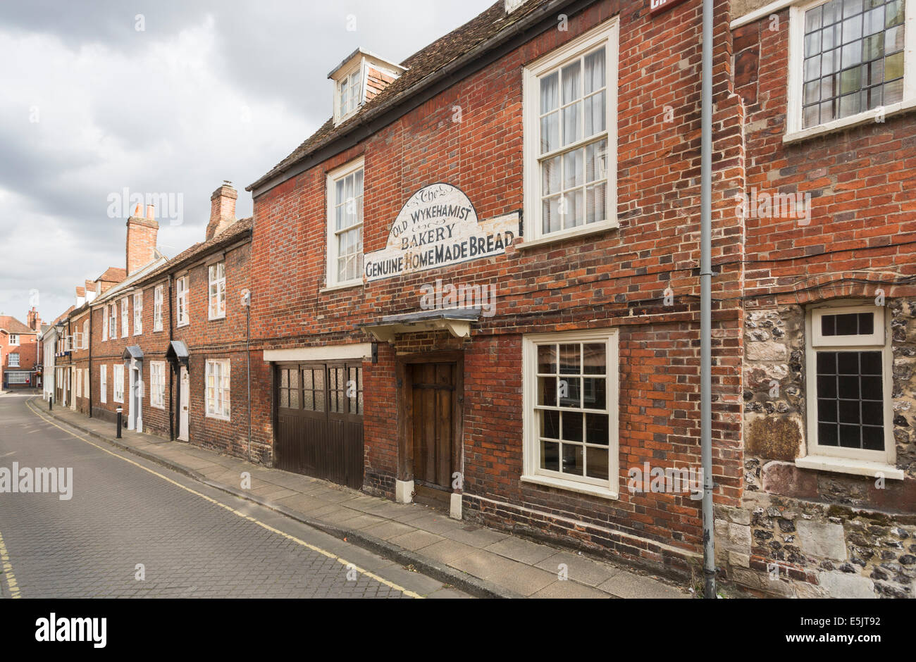 Canon Street, Winchester, Zeile terrassenförmig angelegten Häuser mit Schild "Alte Wykehamist" Bäckerei, echte Hause gebackenes Brot Stockfoto