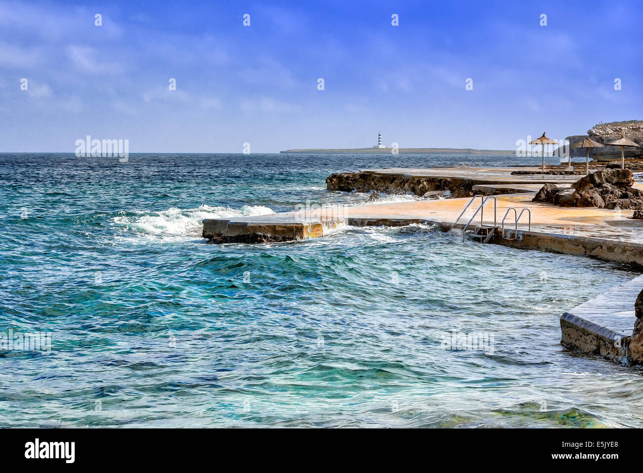 Blick auf S´Algat Strand von Menorca mit Leuchtturm im Hintergrund, Balearen, Spanien Stockfoto