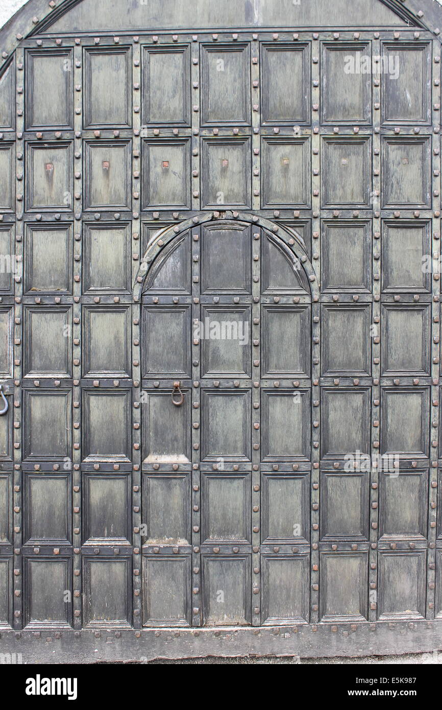 Riesige, alte Hof Tür mit internen Schlupftür bei Lanhydrock, Cornwall, England, UK Stockfoto