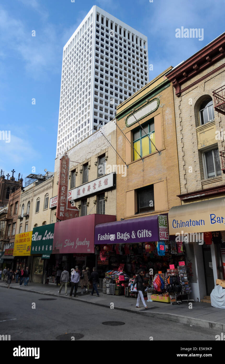 Geschäfte und Menschen in Grant Avenue, Chinatown, San Francisco, mit einem Wolkenkratzer im Hintergrund Stockfoto