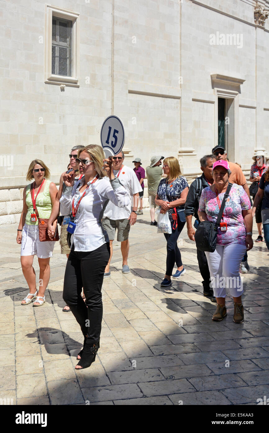 Reiseleiter hält die Flagge des Kreuzfahrtschiffes und spricht in Echtzeit in mike, um Audio mit ihrer Gruppe Dubrovnik Croatia Dalmatia Adriatic zu verbinden Stockfoto