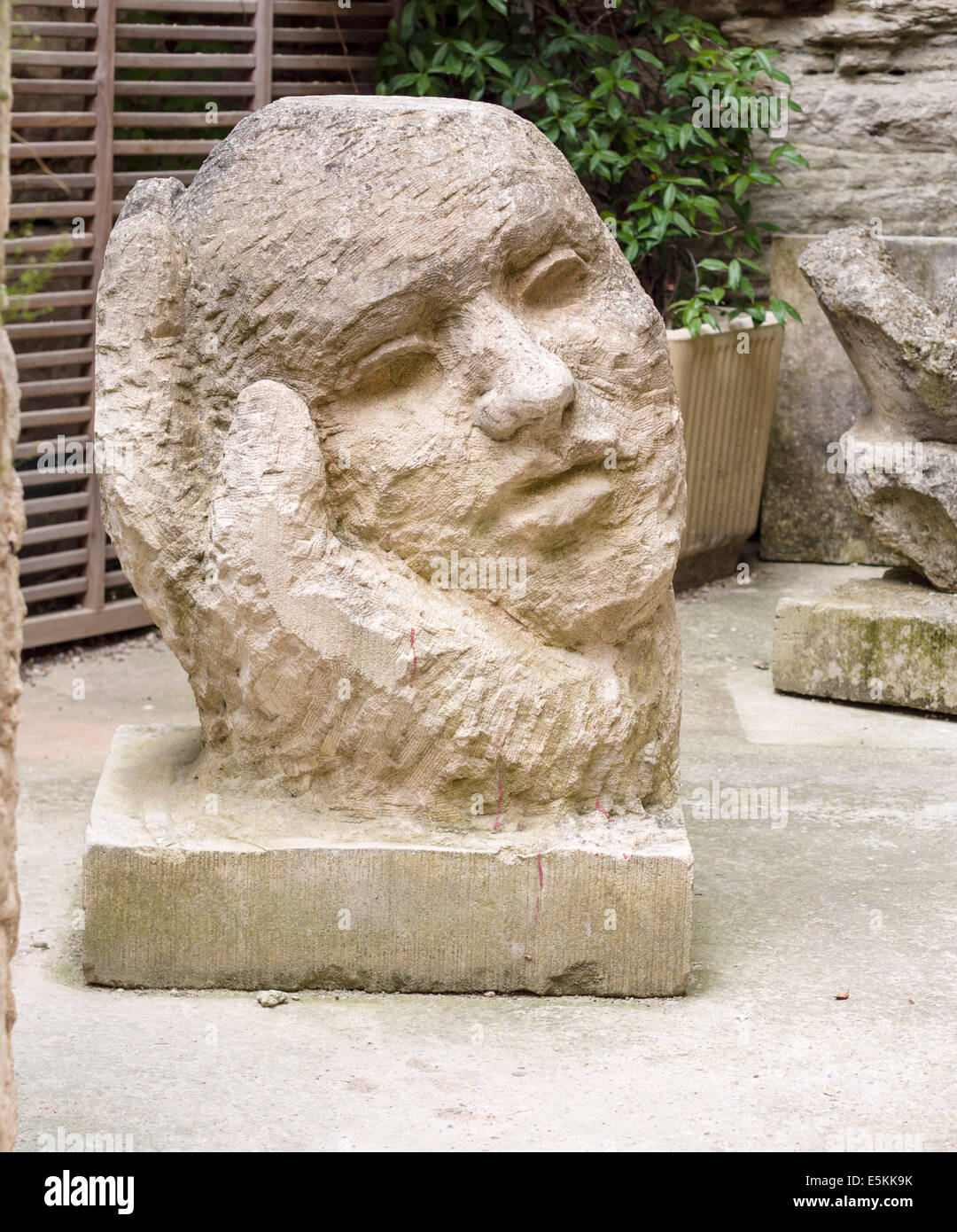 Neue Kunst: Hand und Kopf-Skulptur. Ein großer Block aus Stein gemeißelt  vor kurzem in eine große Hand wiegte den Kopf Stockfotografie - Alamy