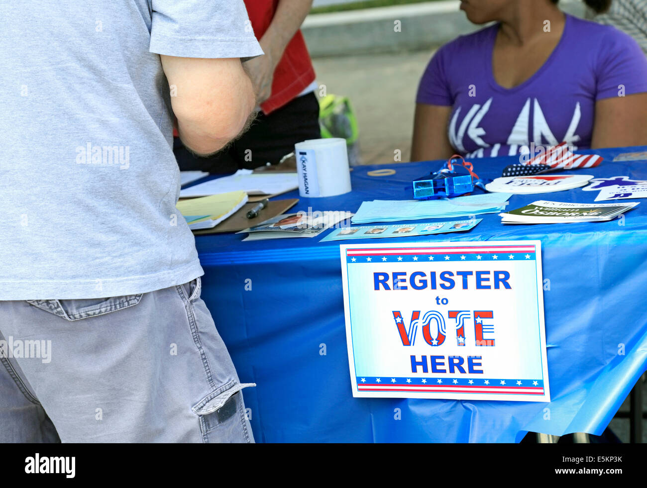 Junger Mann am demokratischen Partei Voting Registrierung Stand mit Zeichen. Stockfoto