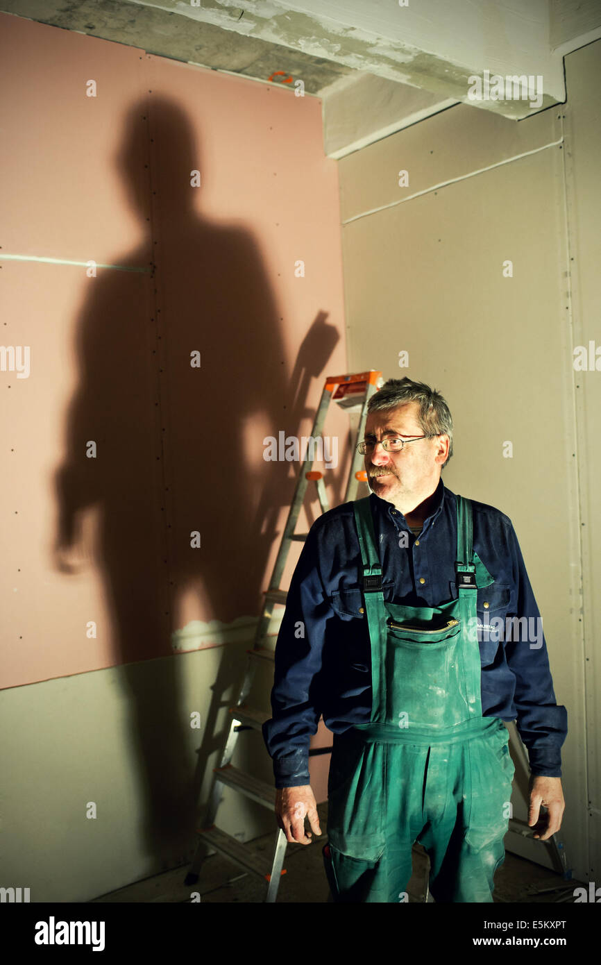 Mann bei der Arbeit mit großen Schatten in den Rücken Stockfoto