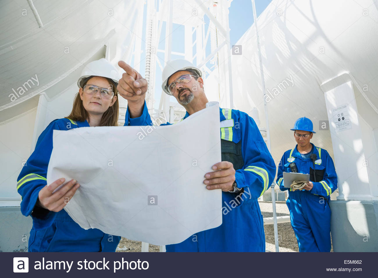 Arbeitnehmer mit Blaupausen an Gas-Anlage Stockfoto