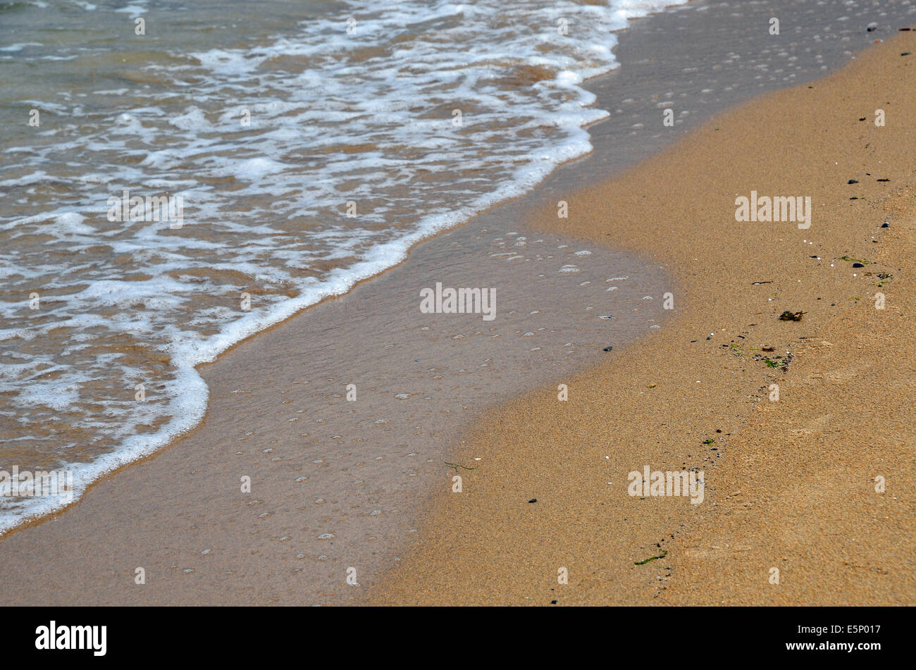 Sand - Wasser plätschern auf einen Sandstrand und Meer. Stockfoto