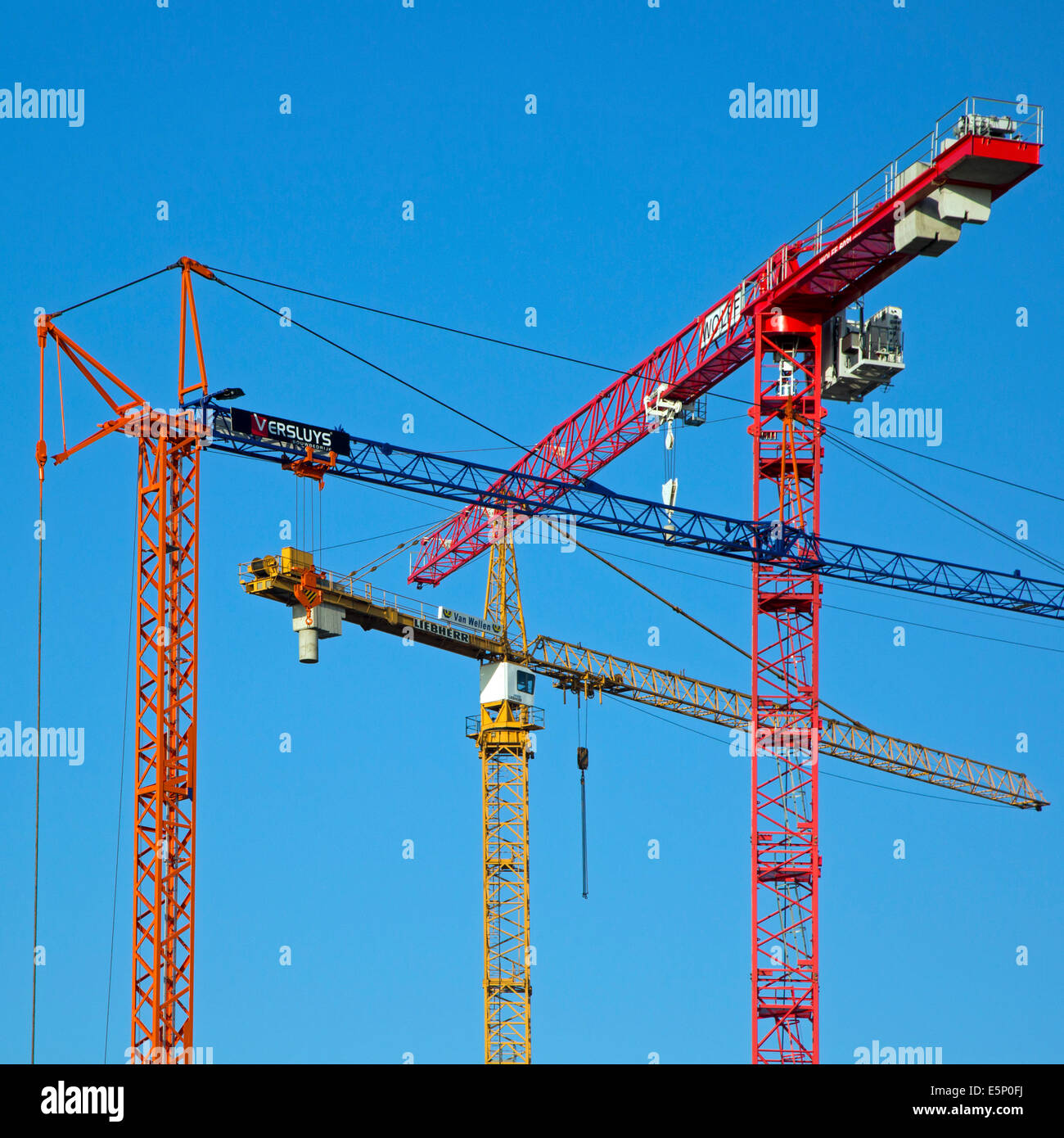 Drei Baukräne / Turmdrehkran gegen blauen Himmel Stockfoto
