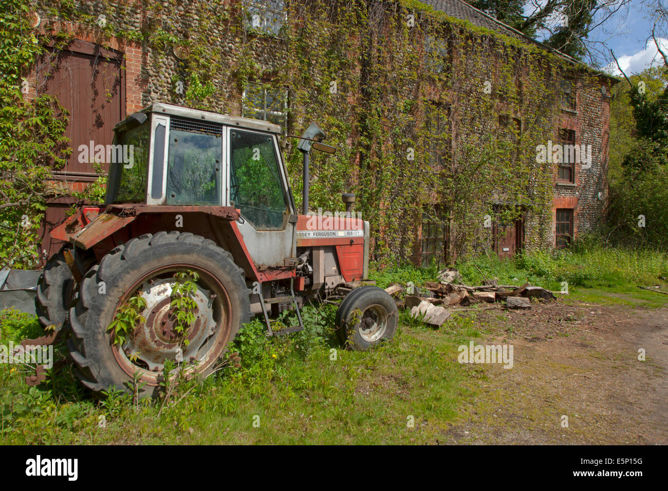 Alten Traktor Massey Ferguson 698T Traktor vor alten Bauernhof-Norfolk Stockfoto