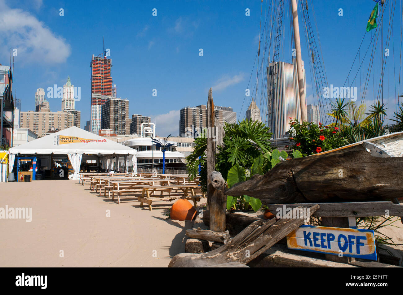 Die Water Taxi Beach-Konzession in der South Street Seaport in New York. Water Taxi Beach. Hinter dem Pier 17. Die gleichen Leute Wassertaxi, schuf dieser künstlichen Strand auf der Rückseite Pier 17, wo der Spaß ist garantiert. Am Wochenende gibt es DJs und hat auch beneidenswerte Aussicht auf die Brooklyn Bridge. Stockfoto