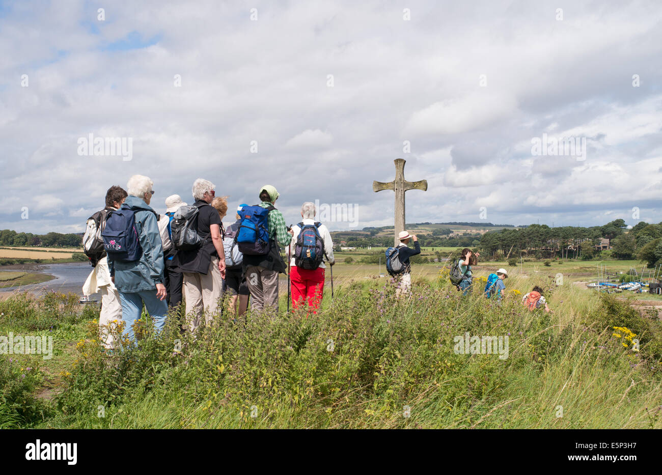 Gruppe von Spaziergängern nähert sich Cuthbert Kreuz am Kirchhügel, Alnmouth, Northumberland, Nord-Ost-England, UK Stockfoto