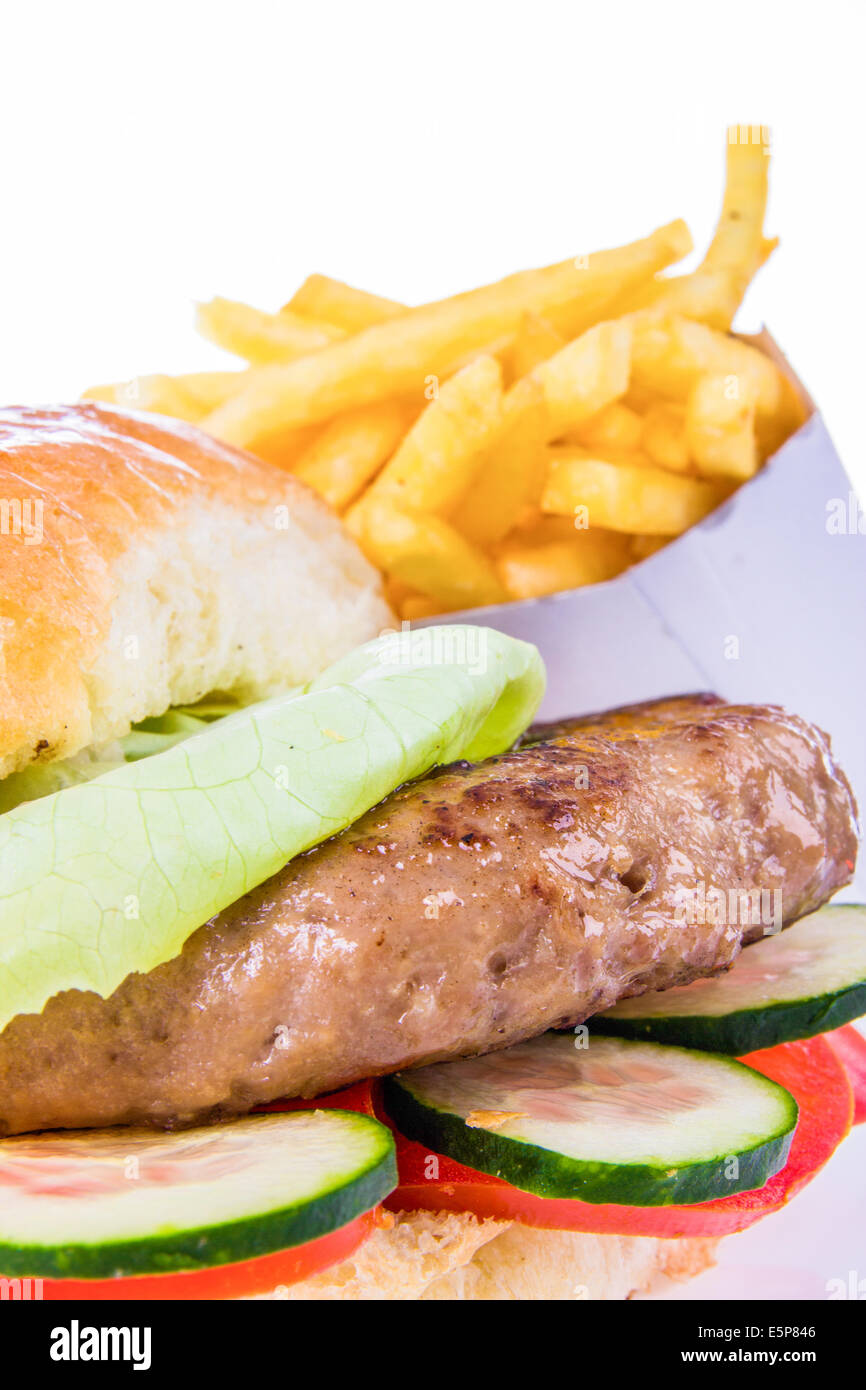 Burger in Brötchen mit Pommes frites, Gurken und Tomaten Salat isoliert in Nahaufnahme Stockfoto