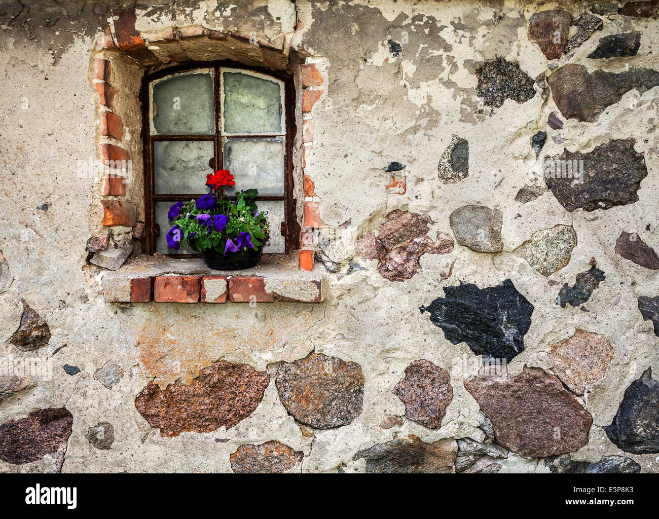 Blumen auf das Fenster des alten Gebäudes Steinmauer. Stockfoto