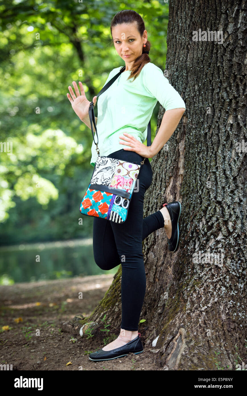 Porträt der jungen Frau mit Handtasche in einem park Stockfoto