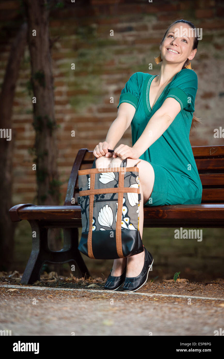 Porträt der jungen Frau mit Handtasche in einem park Stockfoto