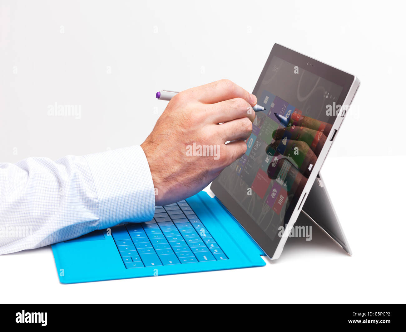 Person die Hand mit einem Stift berühren Anzeige der Microsoft Surface Pro 3 Tablettcomputer isoliert auf weißem Hintergrund Stockfoto