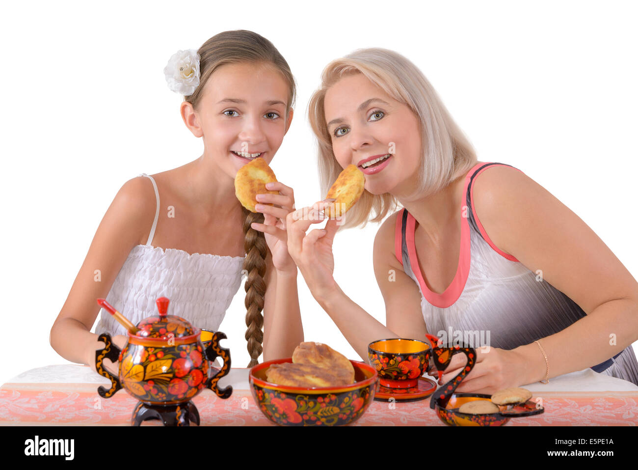 Mutter und Tochter essen Kuchen auf dem weißen Hintergrund Stockfoto