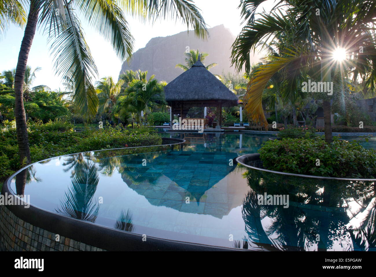 Le Morne Brabant hinter einen Infinity-Pool bei Sonnenaufgang im Hotel Lux Le Morne. Le Morne Brabant Halbinsel, Süd-west-Mauritius Stockfoto
