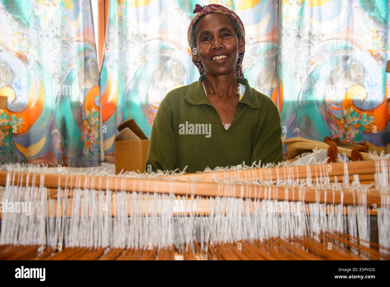 Freundliche Frau arbeitet an einer Hand Webstuhl an einem sozialen Projekt im Hochland von Eritrea, Afrika Stockfoto