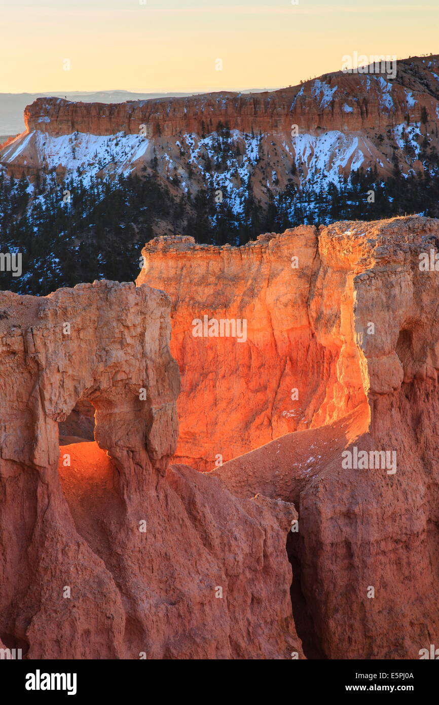 Felsen beleuchtet durch starke Morgenlicht, verschneiten Kulisse, Queens Garden Trail am Sunrise Point, Bryce-Canyon-Nationalpark, Utah, USA Stockfoto