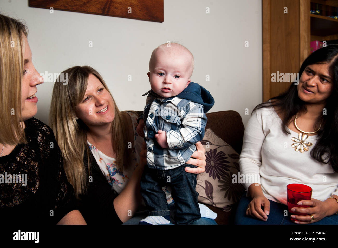 Mütter mit Baby zu Hause posiert Stockfoto
