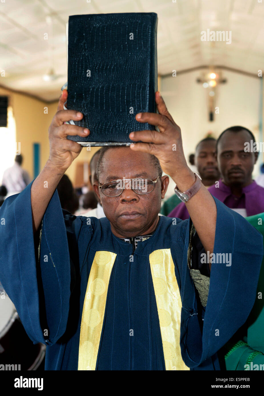 Römisch-katholischer Priester hält Bibel im sonntäglichen Gottesdienst in Maiduguri, Nigeria Stockfoto