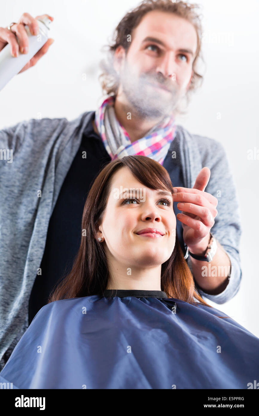 Männliche Coiffeur geben Frauen Hairstyling mit Haarspray im shop Stockfoto