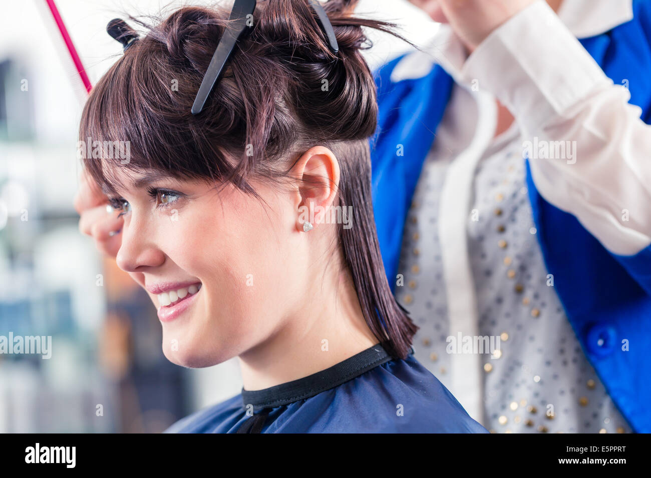 Weibliche Coiffeur Teilen Frauen Haare in Abschnitten mit Clips im shop Stockfoto
