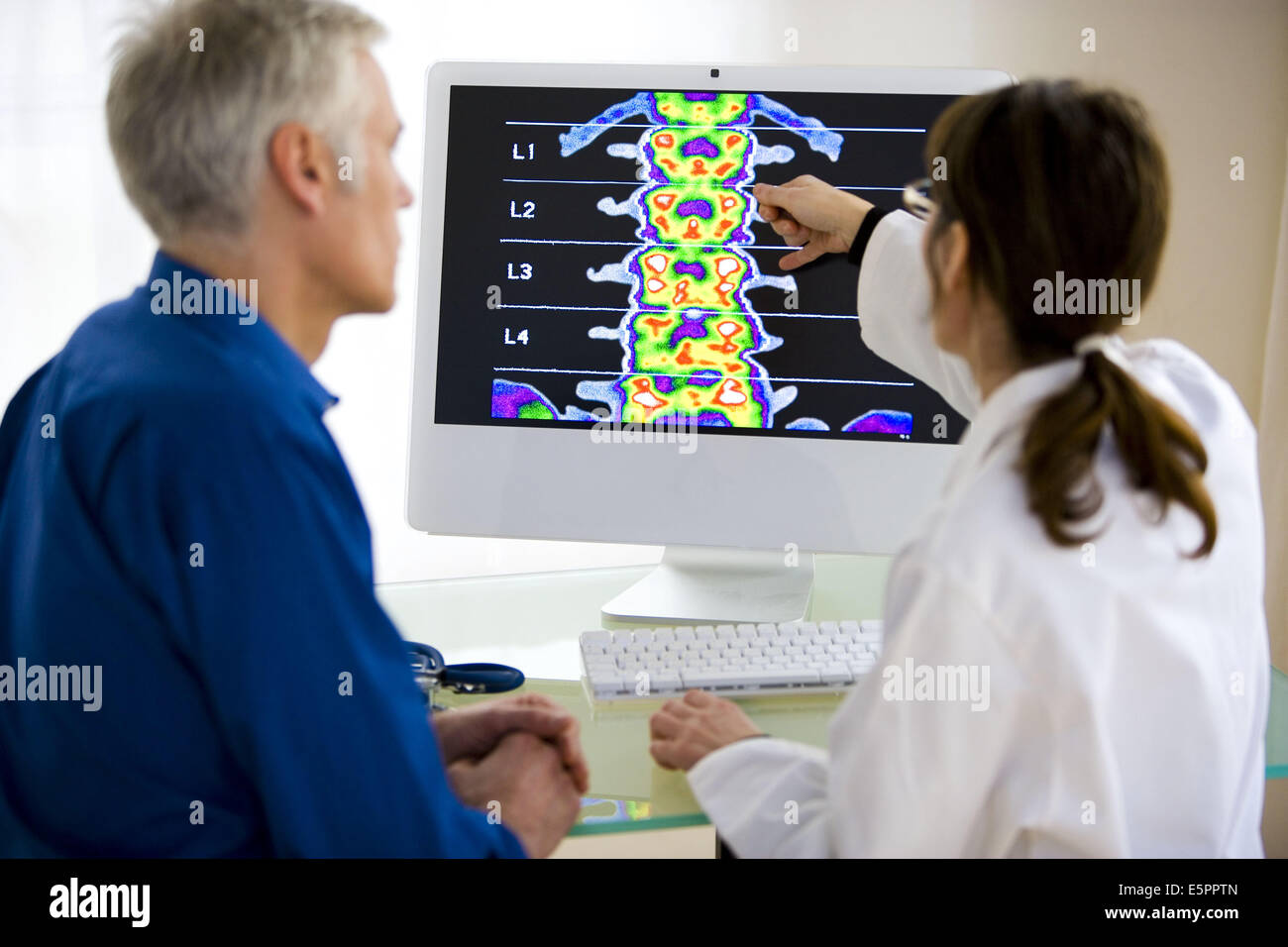 Arzt zeigt Patienten ein Rückgrat Densitometrie. Stockfoto