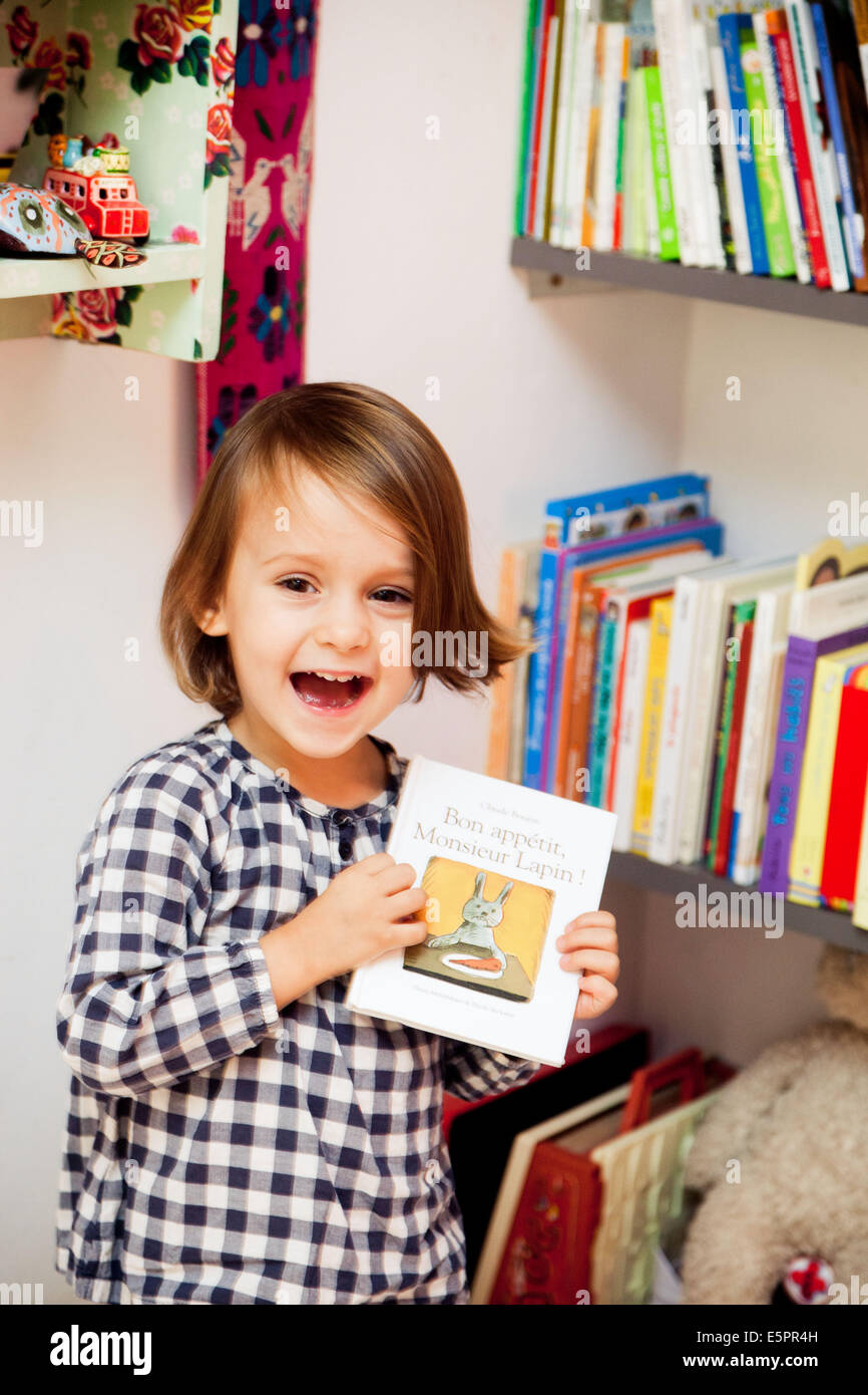 3-jähriges Mädchen mit Buch. Stockfoto