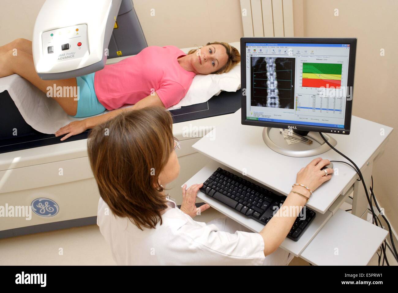 Ein Arzt benutzt ein Knochen Densitometer zur Messung der optischen Dichte der unteren Rachis (Backbone) der Patientin zu diagnostizieren Stockfoto