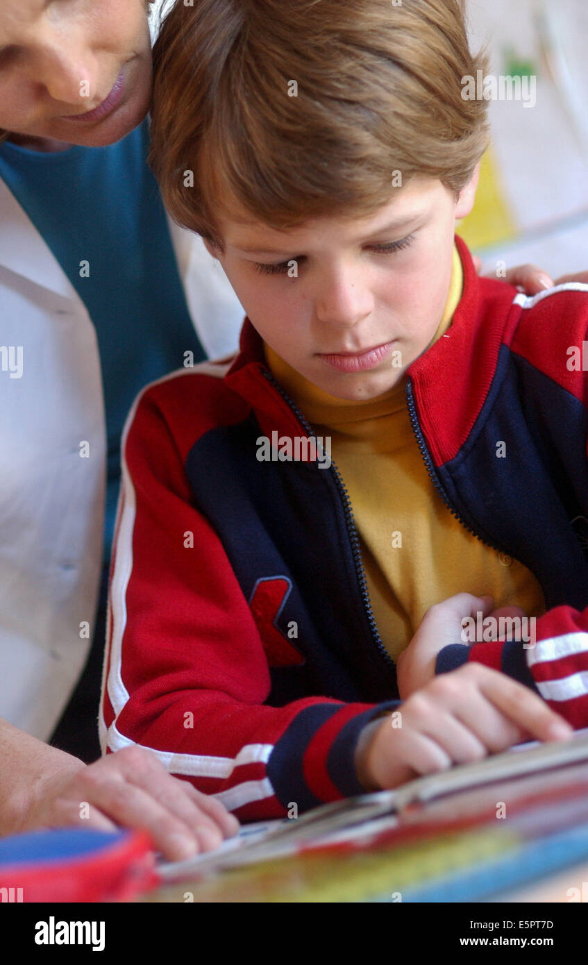 Mutter hilft Sohn 7-Year-Old, seine Hausaufgaben zu tun. Stockfoto