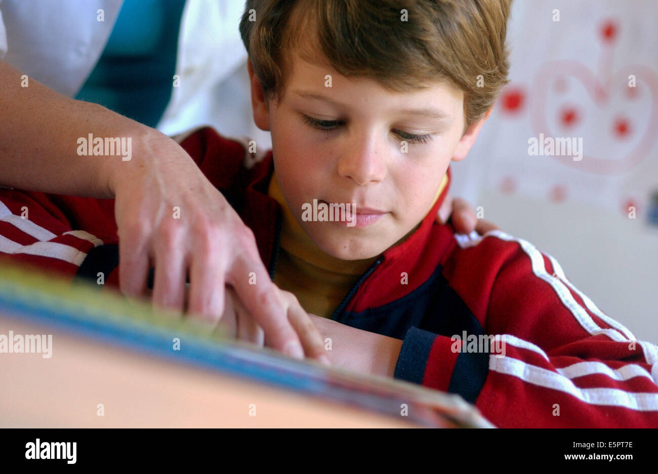 Mutter hilft Sohn 7-Year-Old, seine Hausaufgaben zu tun. Stockfoto
