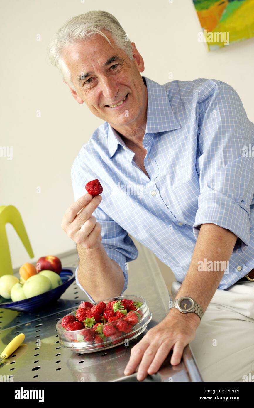 50 Jahre alter Mann ein Erdbeeren essen. Stockfoto