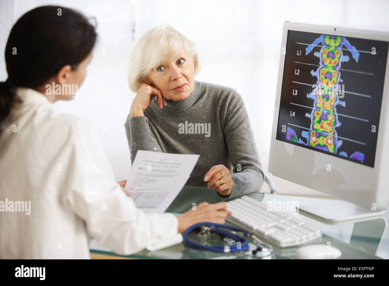 Arzt Rückgrat Densitometrie Röntgen mit einer Patientin zu diskutieren. Stockfoto