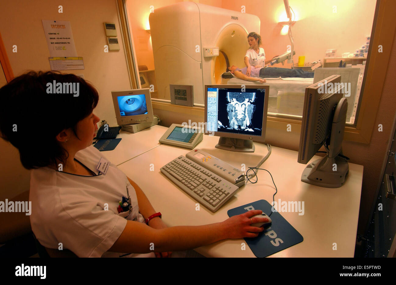 Techniker, die Überwachung eines Patienten einen Computertomographie (CT)-Scan des Gehirns. Stockfoto