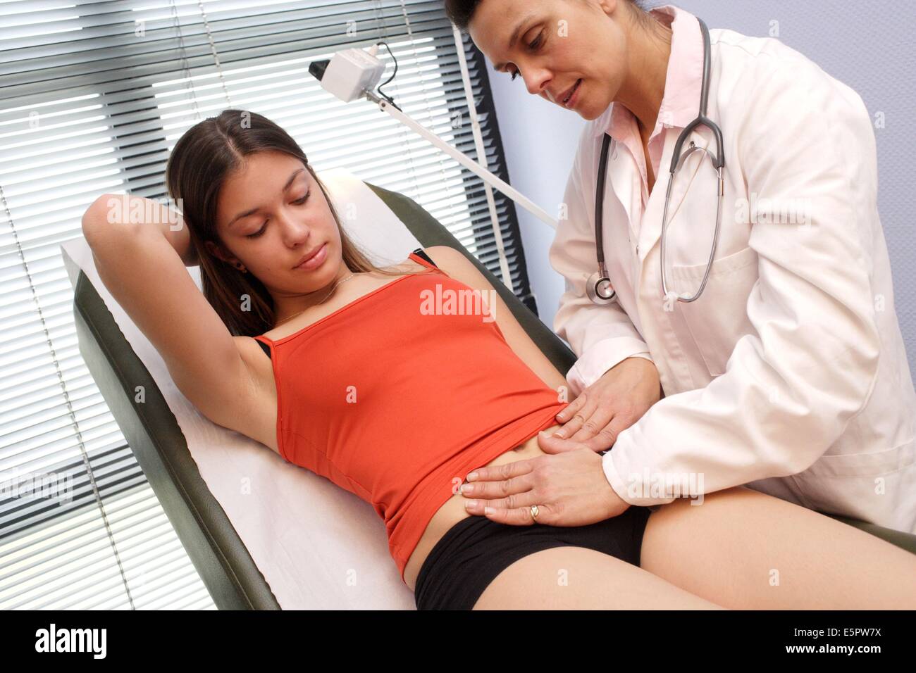 Ein Arzt untersucht den Bauch eines Mädchens durch Abtasten. Stockfoto