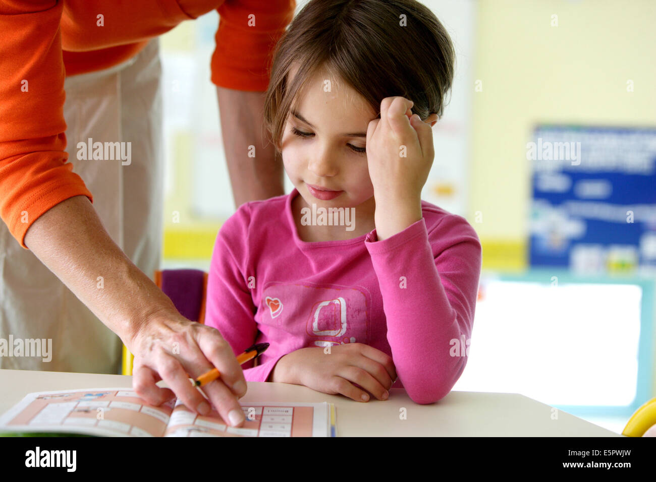 6 Jahre altes Mädchen in der Schule mit Lehrer. Stockfoto