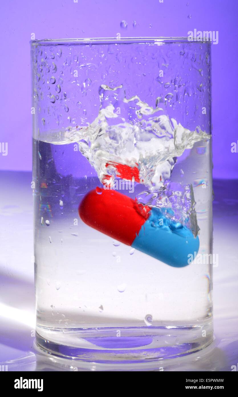 Droge-Kapsel auf ein Glas Wasser. Stockfoto